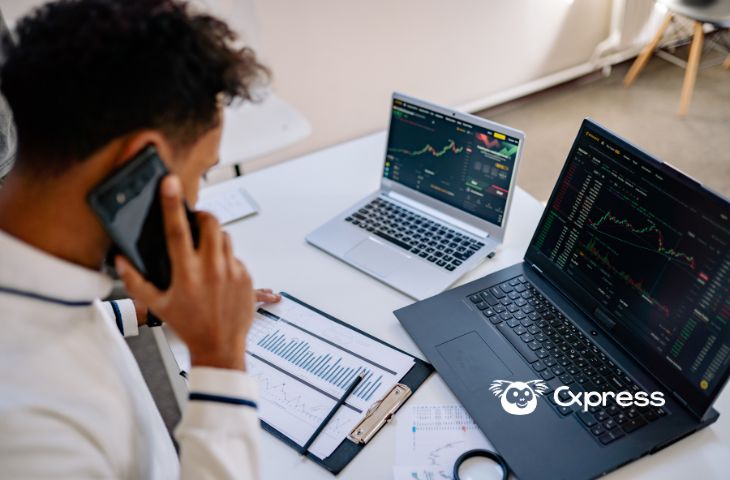 Profissional a analisar dados de CRM e CXM em dois portáteis