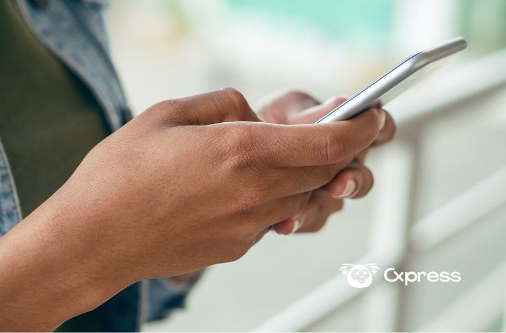 Atendente a consultar o guião de atendimento no telemóvel durante uma conversa no WhatsApp
