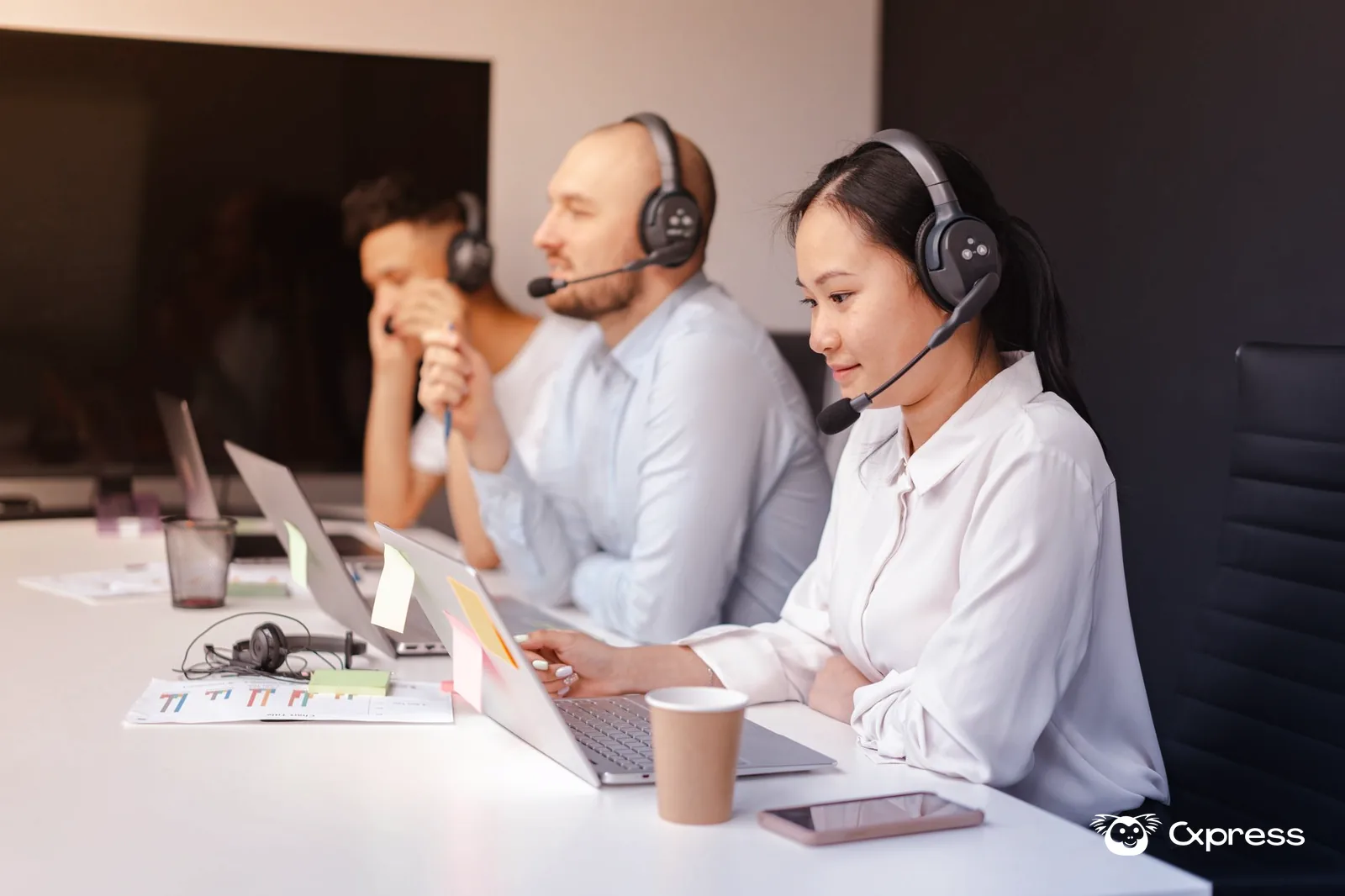 Equipa de atendimento a analisar um dashboard de experiência do cliente num escritório